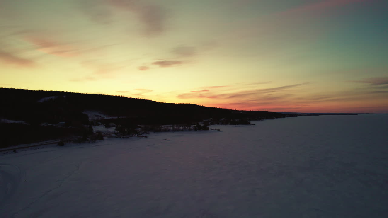drone volando sobre un lago congelado en canadá en la hora dorada