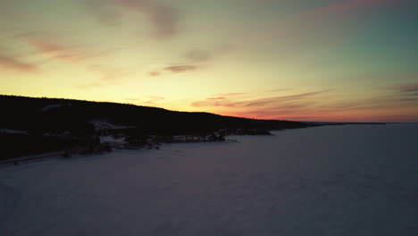 flying drone above a frozen lake in canada at golden hour