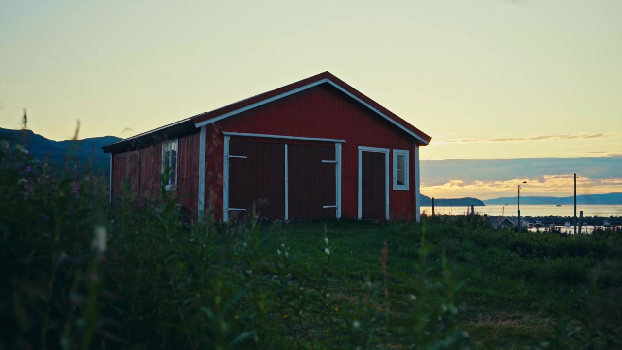 Traditionel rød træhytte ved en søbred. Timelapse.