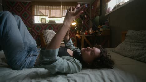 young woman using phone in bedroom