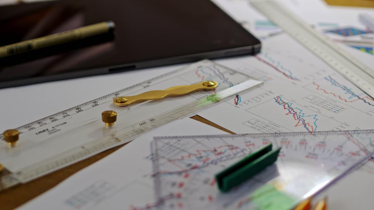 Professional design table, rulers, pencils, charts, notebook under soft light