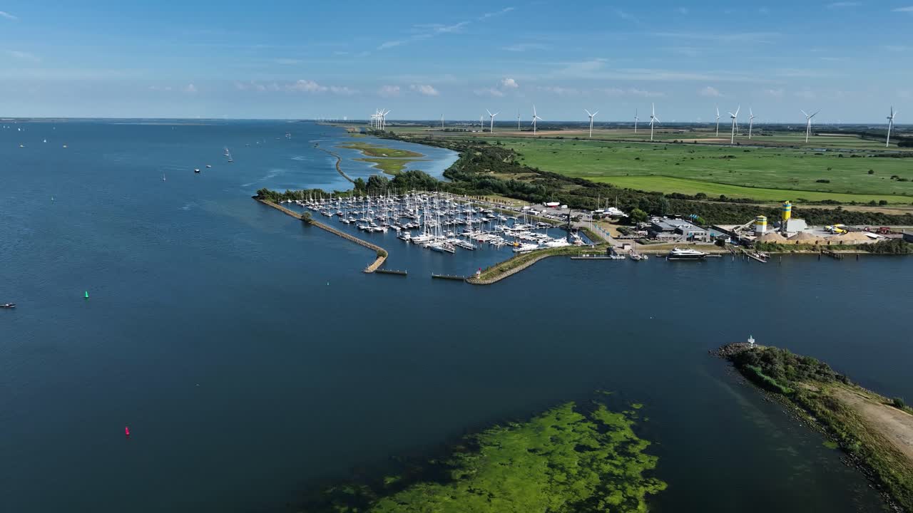 회전하는 풍력 터빈을 배경으로 네덜란드 레크리에이션 항구를 향해 비행