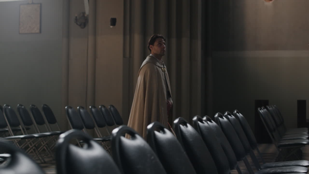 Man in cape walking through church