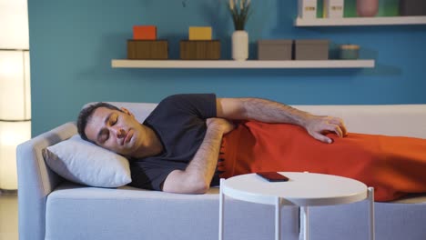 hombre posponiendo el despertador en su sueño.