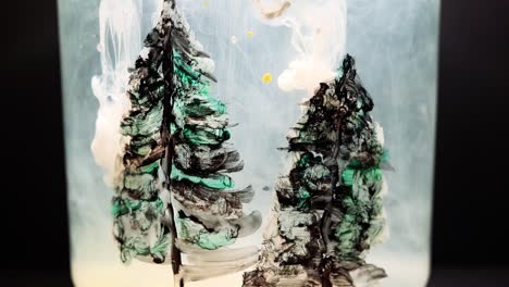 white paint floating in water tank with pine tree drawing inside. stable shot with the sony a7iii.