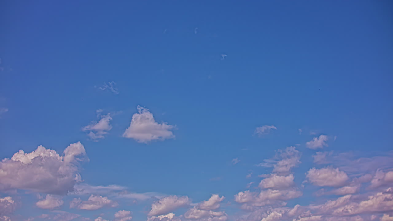 화창한 일몰에 빠르게 떠다니는 하얀 솜털 구름이 있는 푸른 하늘의 정적 시간 경과