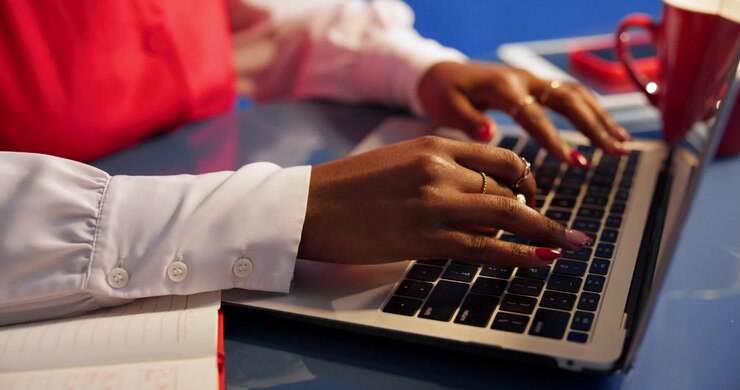 Close-up of Woman Typing on Laptop in Office