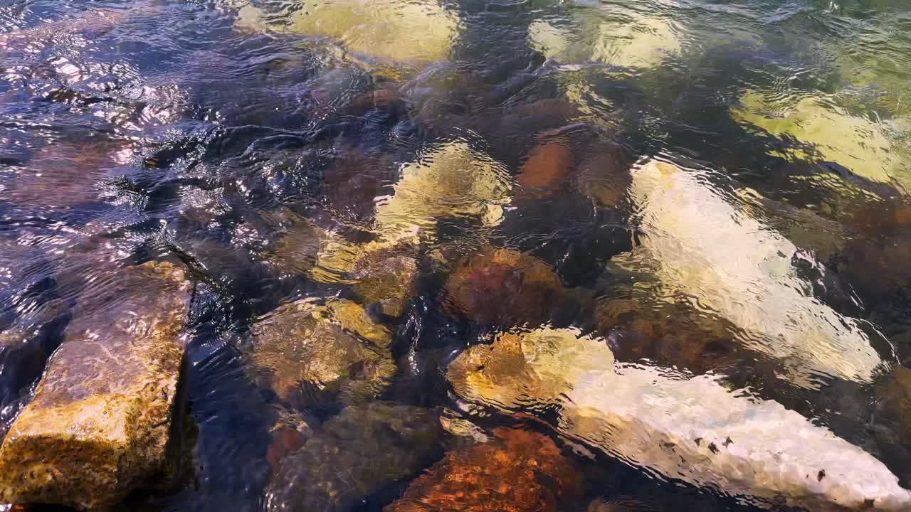 A Serene Exploration of Underwater Rocky Terrain: The Calm Waters Revealing Vibrant Stones and a Glimpse of Nature's Artistic Patterns