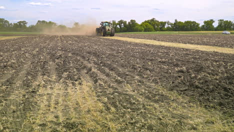 agricultural tractor moving on farming field. farming machinery. rural field