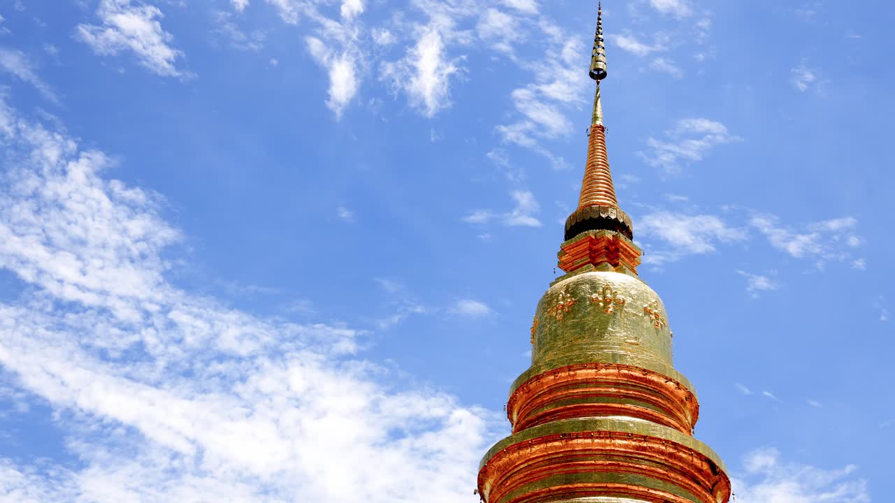 Time lapse di cielo blu con nuvole bianche sopra la splendida pagoda Phrabarommatat Hariphunchai presso Wat Phra That Hariphunchai nella provincia di Lamphun in Thailandia.