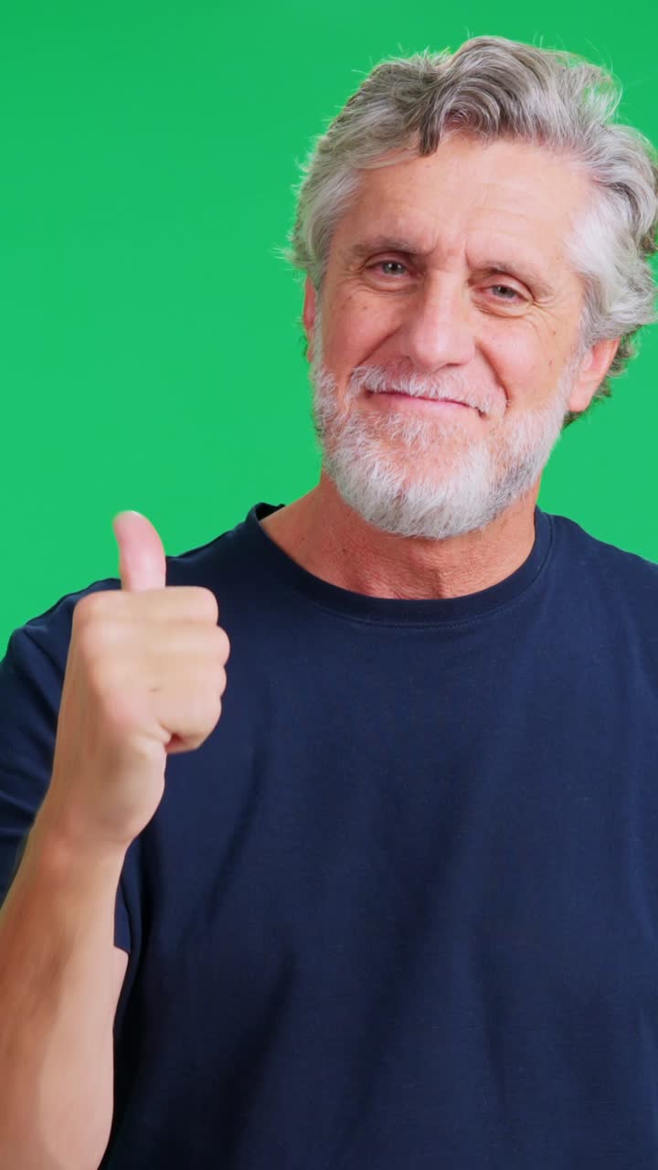 Äldre man ler och ger tummen upp på greenscreen