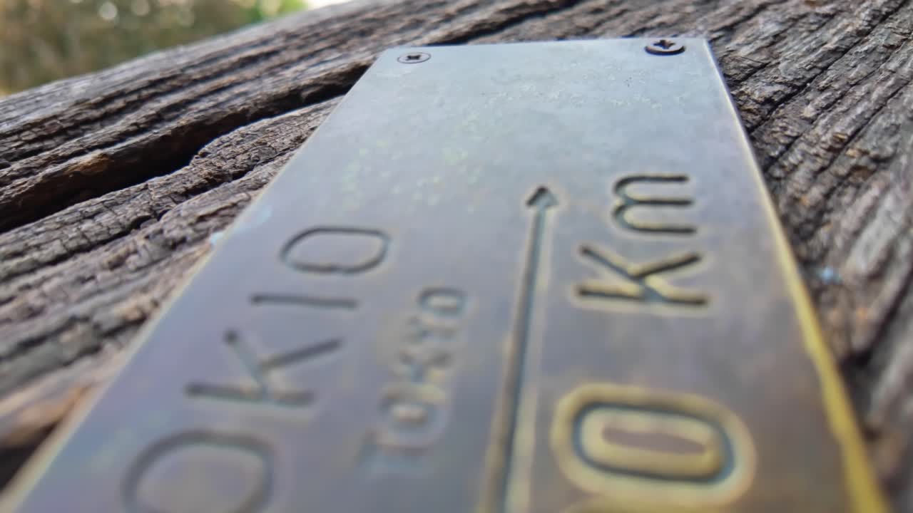 Close-up of a brass plate indicating the distance to Tokyo, Japan from the Clock Tower in Sighișoara, Romania