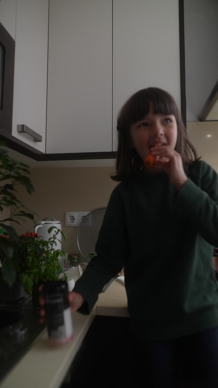 Girl eating a carrot in the kitchen