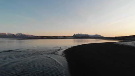 crepúsculo sobre la playa de arena negra en la costa de islandia