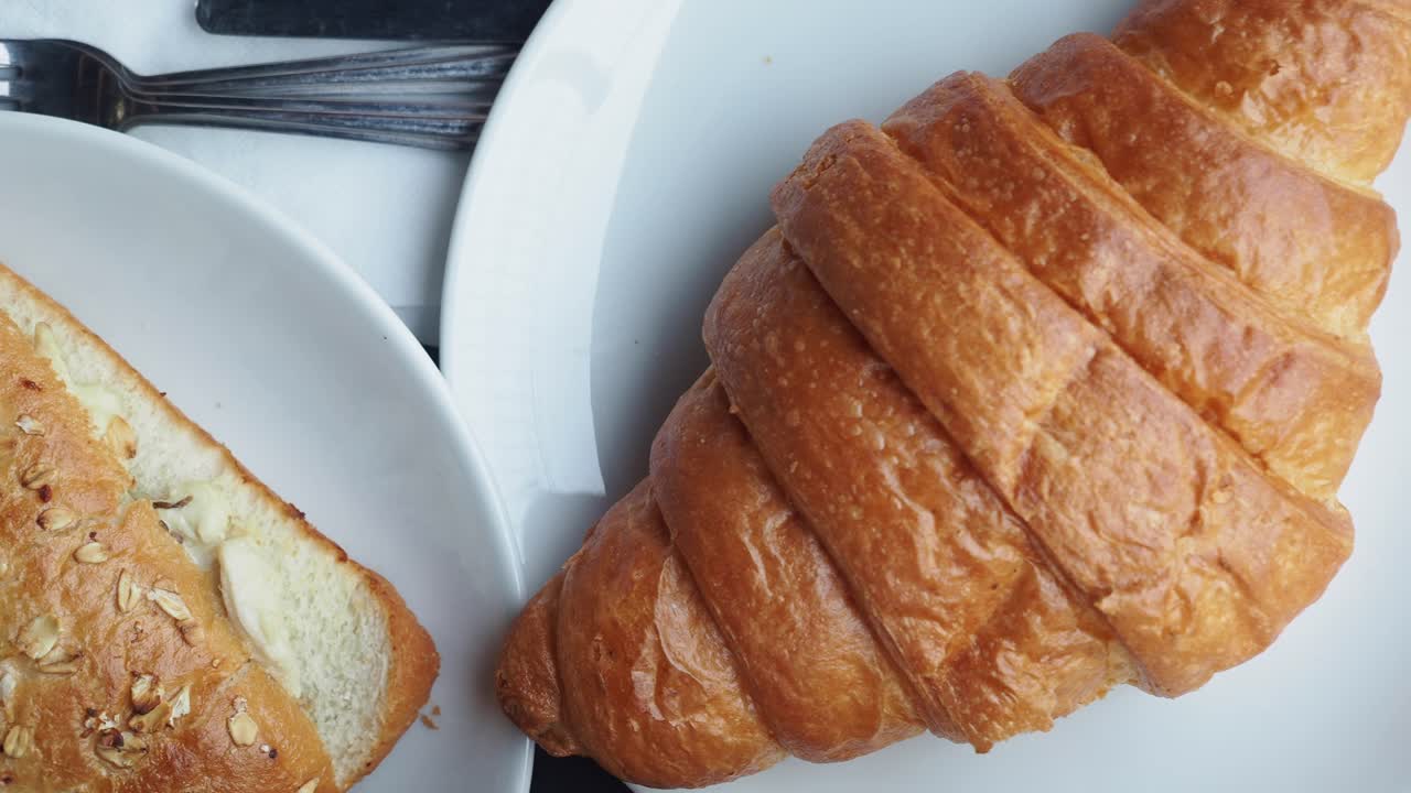 primer plano de un croissant fresco en un plato blanco
