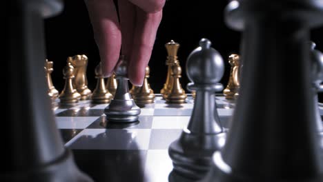 pawn being moved two spaces forward on dramatically lit chess board, low angle