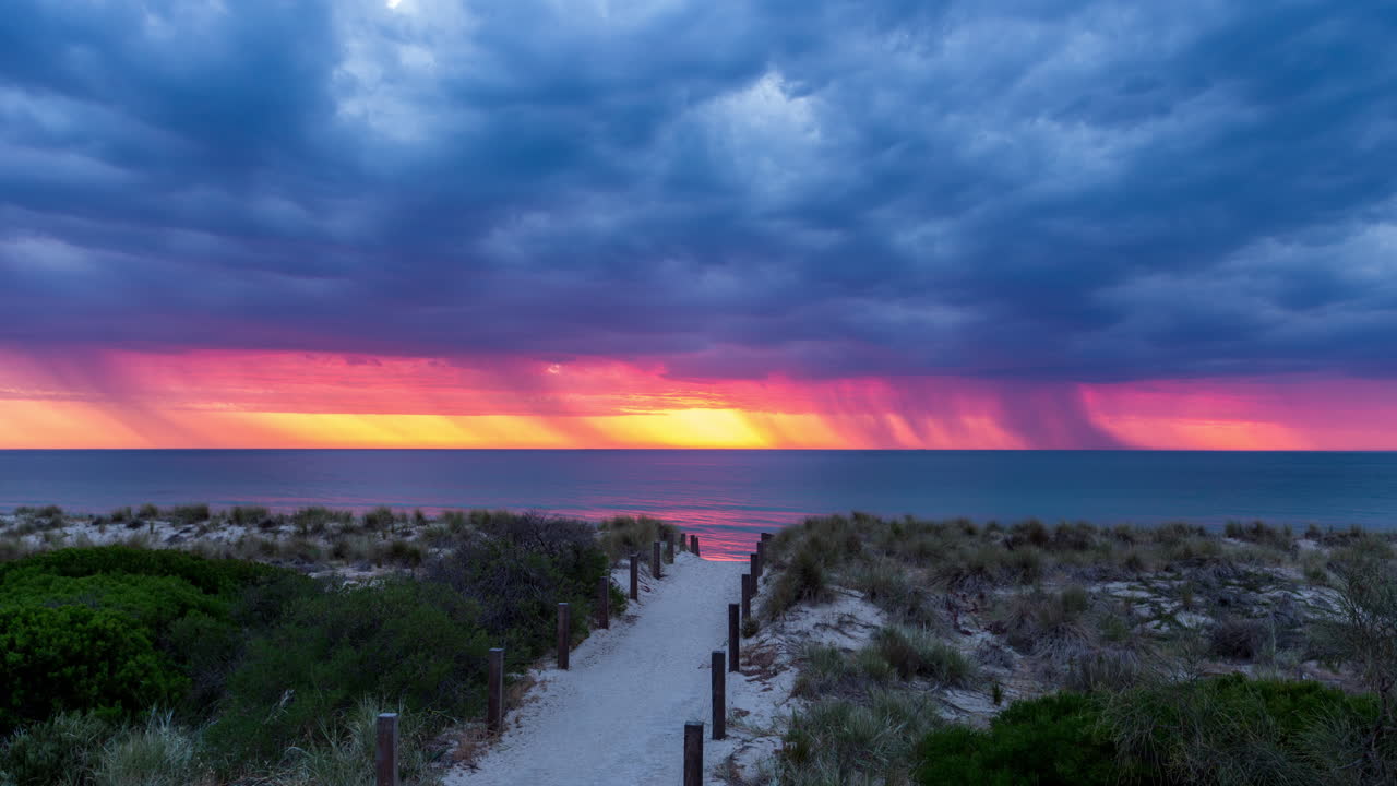 relámpagos y lluvia caen sobre el océano durante una hermosa puesta de sol en henley beach south