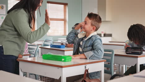 Teacher giving student a high five in the classroom