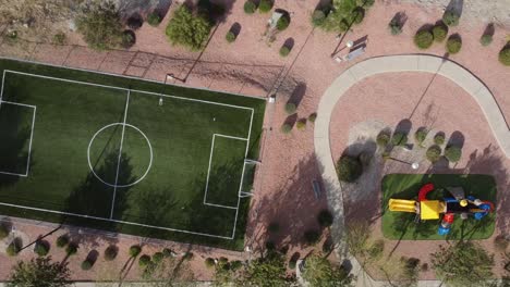 top-down shot of a football pitch and a children's play park and trail