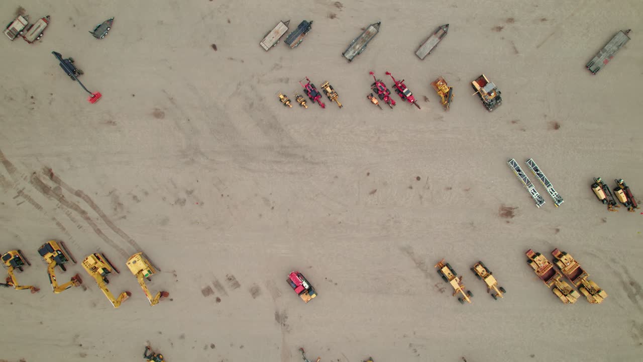 Top-down aerial view of construction equipment displayed at an auction site.