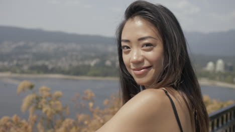 Closeup-of-Cute-Asian-girl-in-great-mood-smiling-to-the-camera,-Slowmo