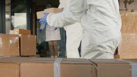los transportistas en trajes antivirales descargan cajas de medicamentos