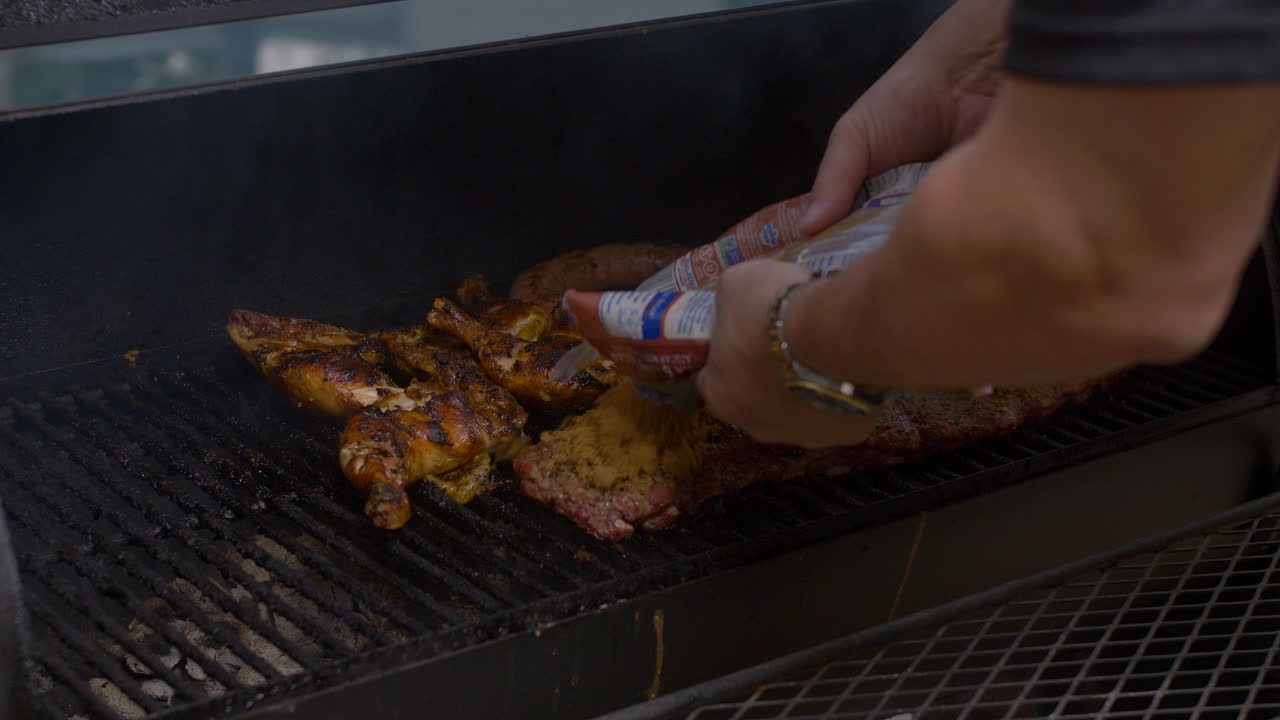 남자가 담배 피우는 구 ⁇ 이에서 바비 ⁇  갈비 ⁇ 에 갈색 설탕을 뿌립니다.