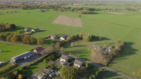 Aerial-drone-shot-of-tilling-up-over-the-countryside-and-big-farm-fields-in-the-Netherlands
