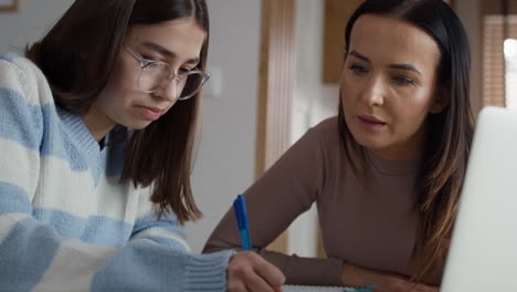 Kaukasische-Mutter-Hilft-Ihrer-Tochter-Im-Teenageralter-Bei-Hausaufgaben-Am-Laptop