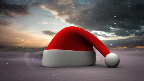 Snow-falling-over-a-santa-hat-icon-on-winter-landscape-against-clouds-in-the-sky