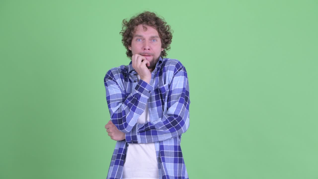 un joven guapo, barbudo y hipster con el cabello rizado.