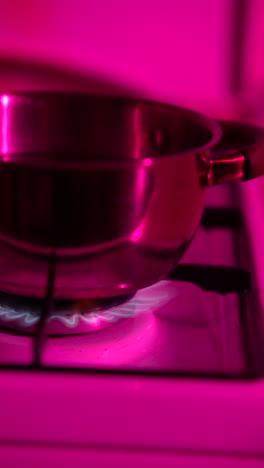 pot on a gas stove with pink light