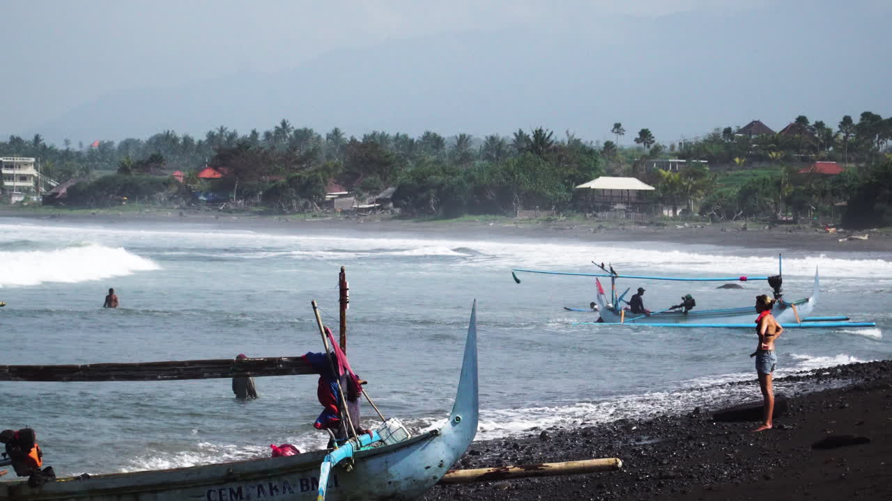 모래 해안선으로 돌아가는 전통적인 아시아 어선