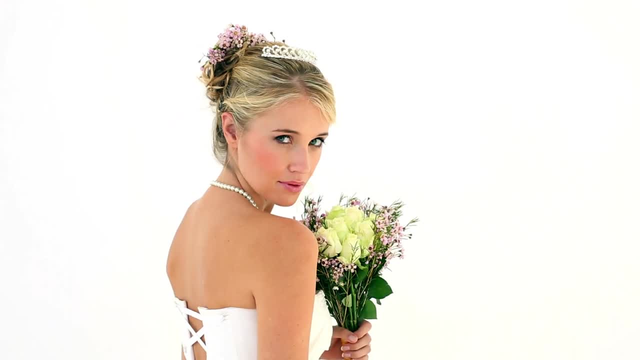 금발 젊은 신부가 카메라에 미소를 짓고 있습니다.