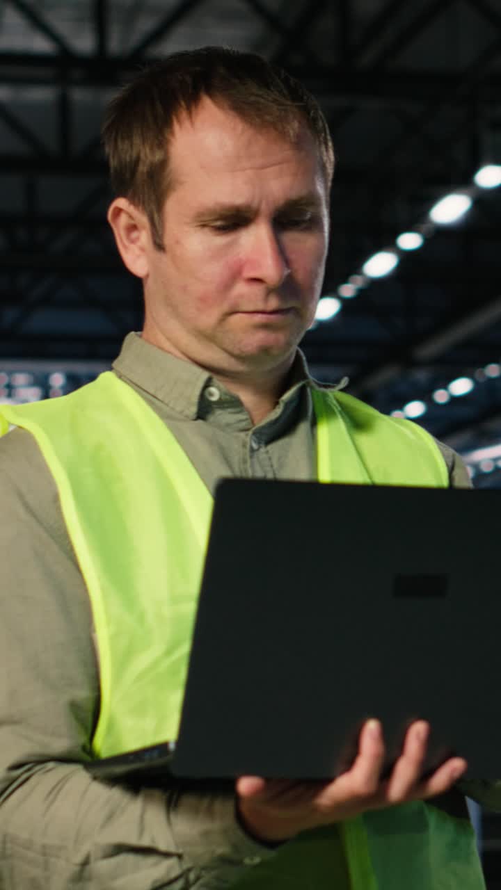 Vertical Video Worker performing inspection over fabrication tasks on laptop