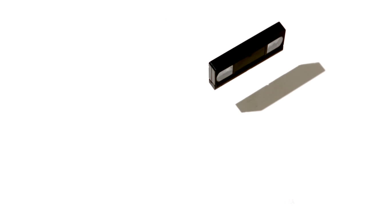 cinta de video cayendo y rompiéndose sobre un fondo blanco