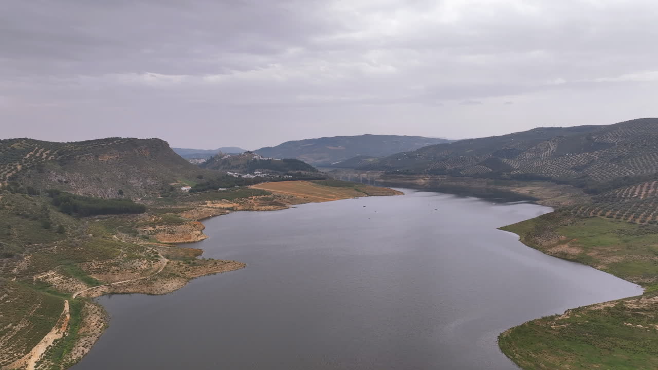 Flight into the gloomy embrace of a grey day at sombre Lake Iznajar Spain
