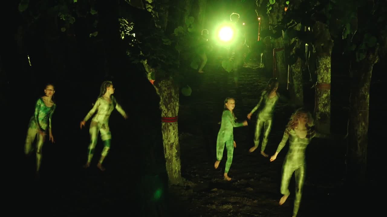Green-Lit Figures in a Dark Forest Performance
