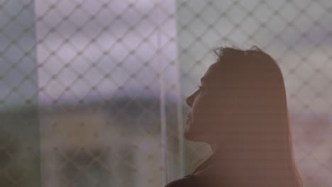 Silhouette-of-brunette-woman-admiring-view-outside-window-in-slow-motion