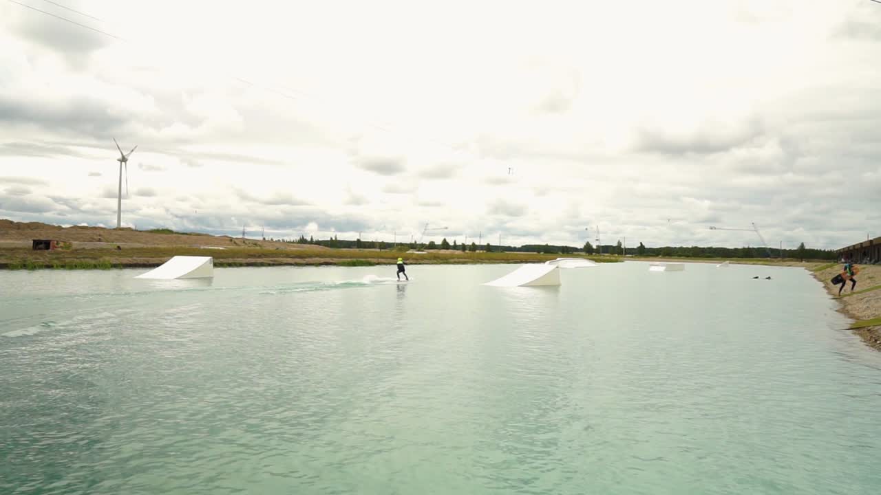 젊은 남자가 워터파크에서 웨이크 보딩을 하고 있다