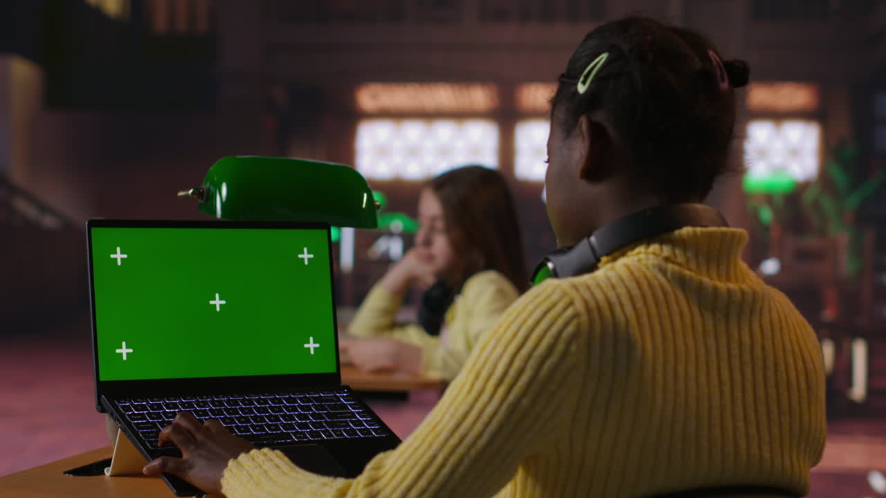 dos chicas estudiando en computadoras portátiles en el aula