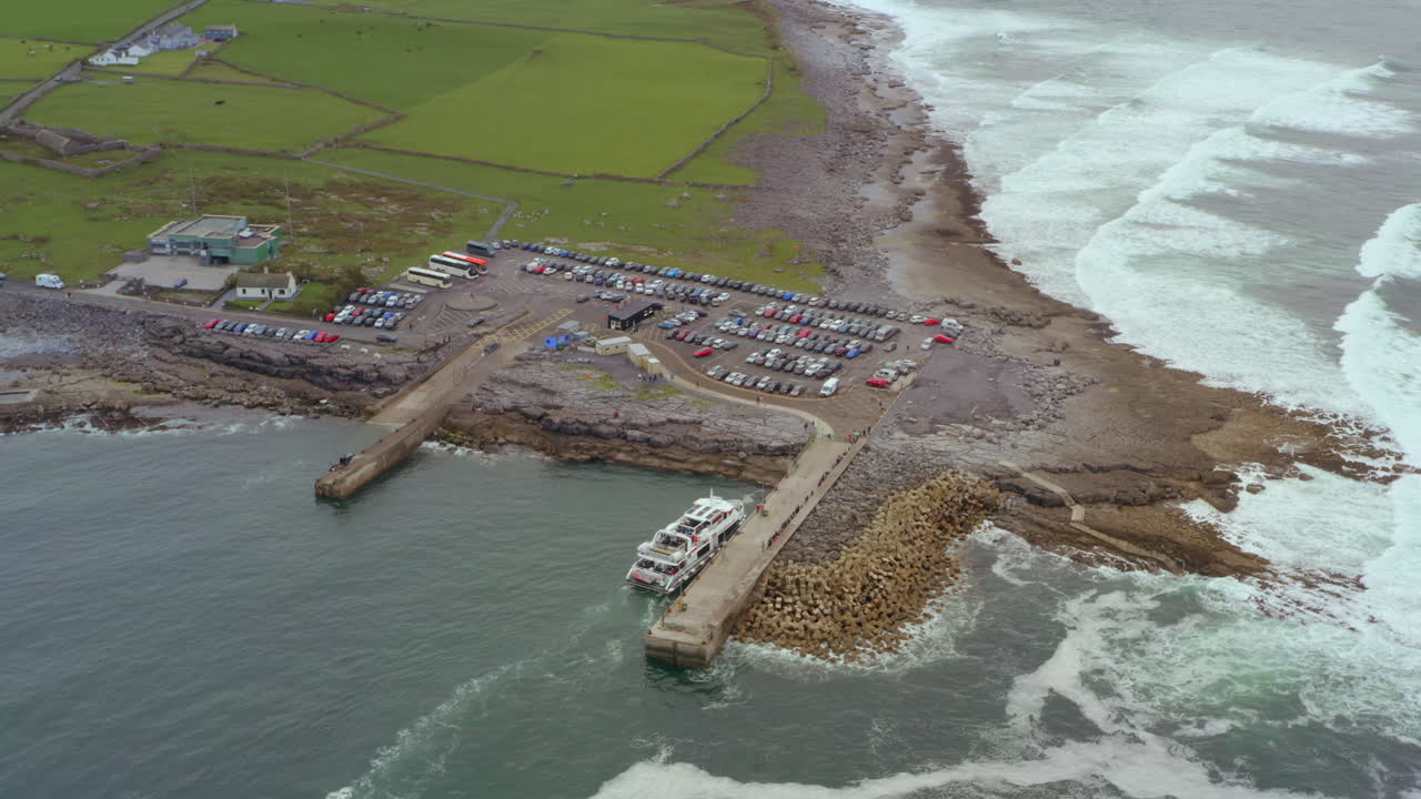 Aerial tracking shot of ferry docking at Doolin Pier. County Clare, Ireland