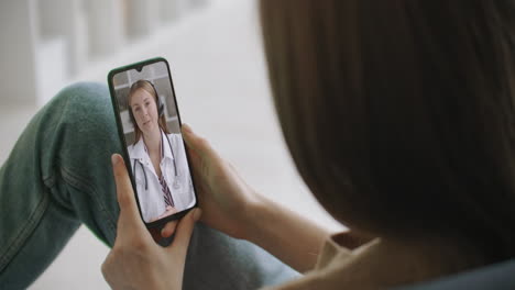 Frau-Nutzt-Medizinische-App-Auf-Smartphone-Und-Berät-Sich-Per-Videokonferenz-Mit-Dem-Arzt.-Frau-Nutzt-Online-Chat,-Um-Mit-Familientherapeuten-Zu-Sprechen-Und-Mögliche-Symptome-Während-Einer-Coronavirus-Pandemie-Zu-überprüfen.