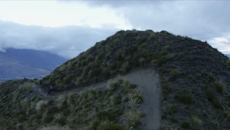 mountain biker riding single trail in new zealand mountain range