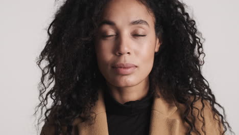 una mujer afroamericana pensativa con fondo blanco.