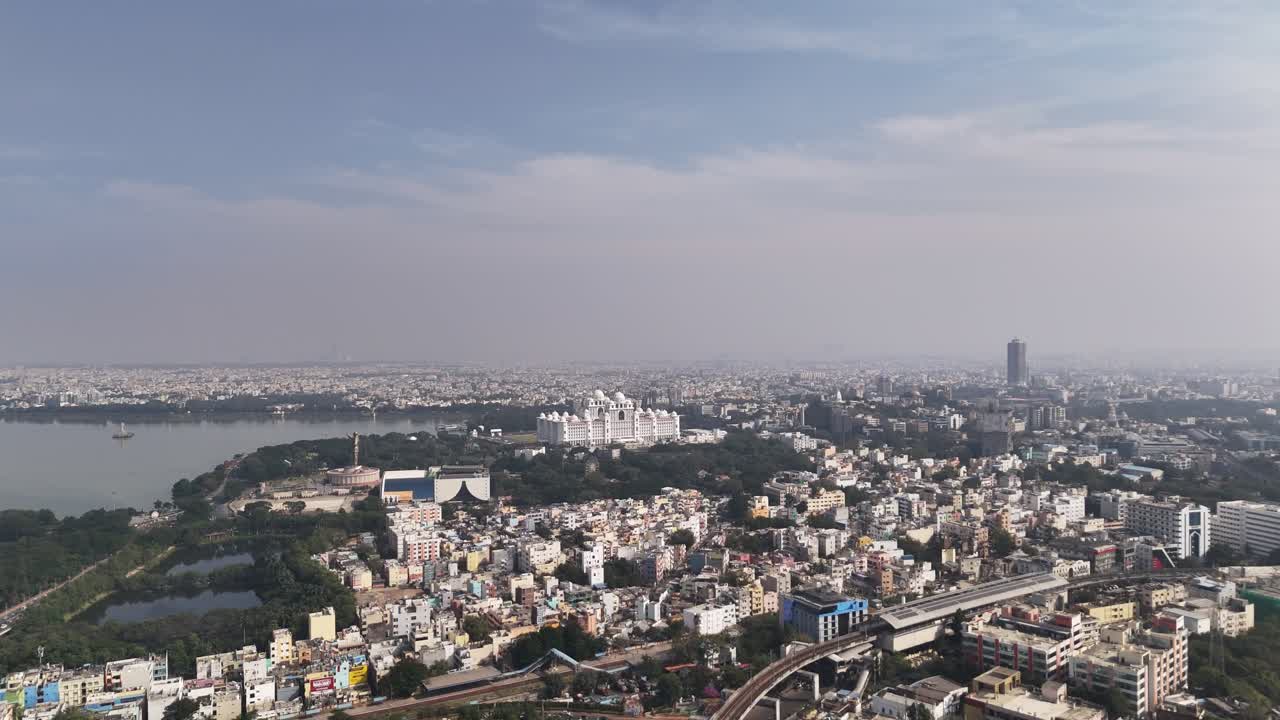 Veduta aerea panoramica di Hyderabad con il lago Hussain Sagar e densi quartieri urbani sotto un cielo diurno limpido. Veduta aerea del lago Hussain Sagar a Hyderabad, il Segretariato del Telangana