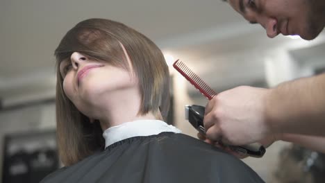 Closeup-View-Of-A-Hairdresser's-Hands-Cutting-Hair-With-Scissors