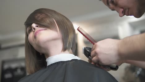 vista de cerca de las manos de un peluquero cortando el cabello con tijeras