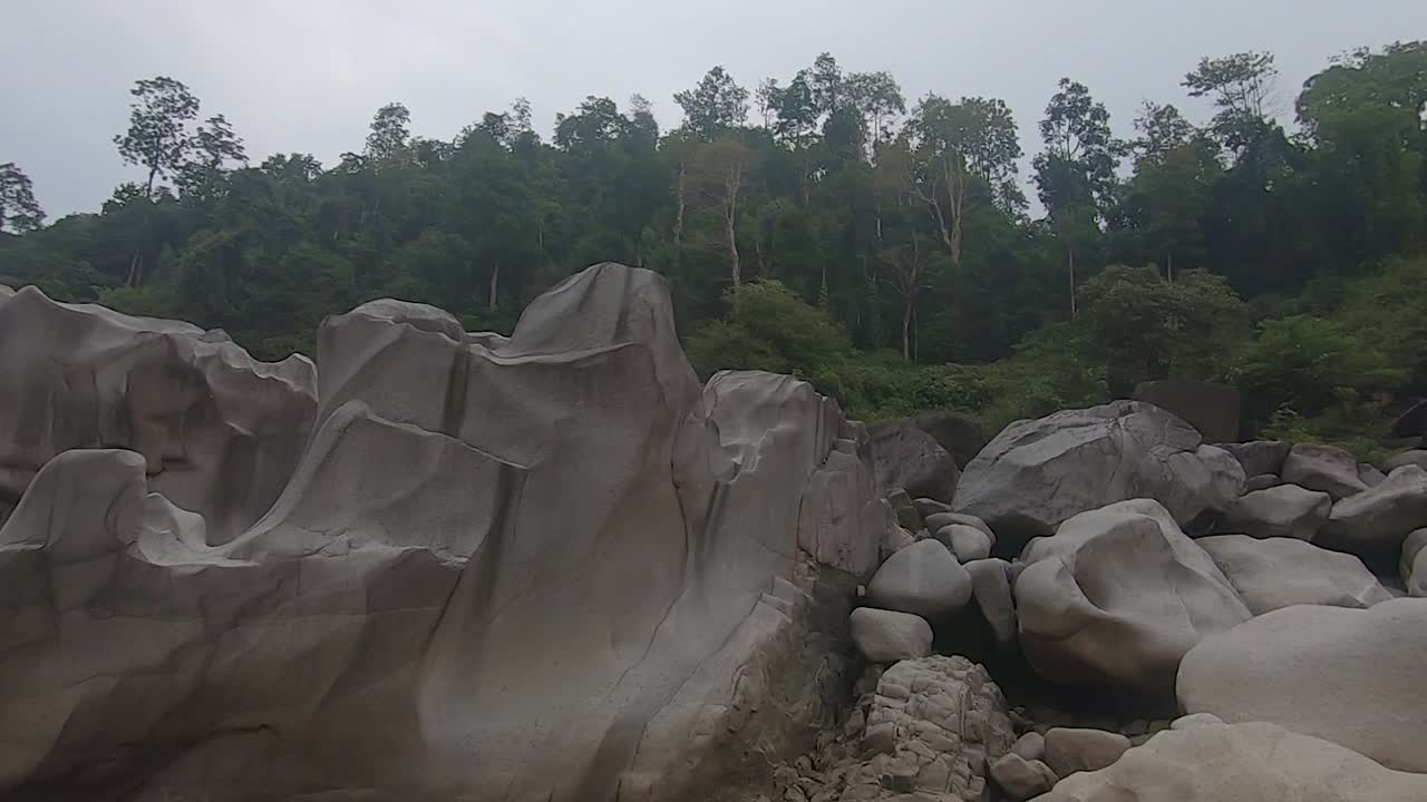bosques verdes con piedra blanca brillante en forma única en el lecho seco del río por la mañana