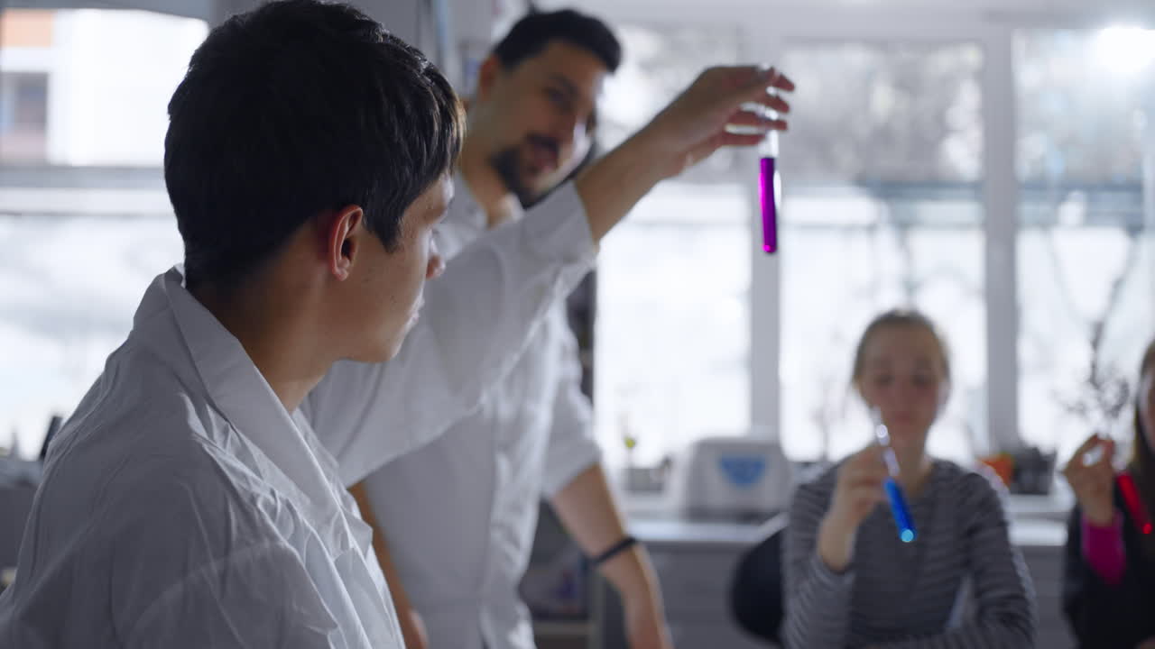 clase de ciencias: estudiantes y maestro experimentando con líquido púrpura